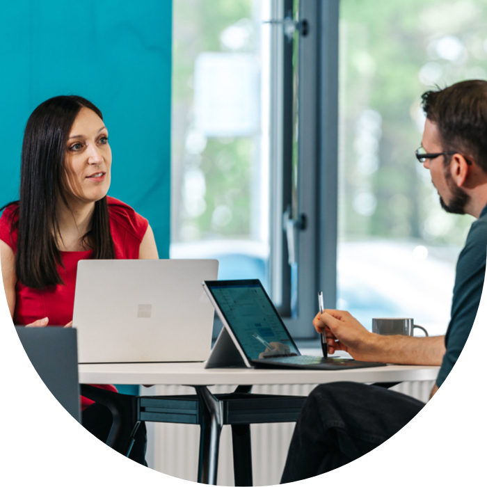 man and woman sat at table with laptops