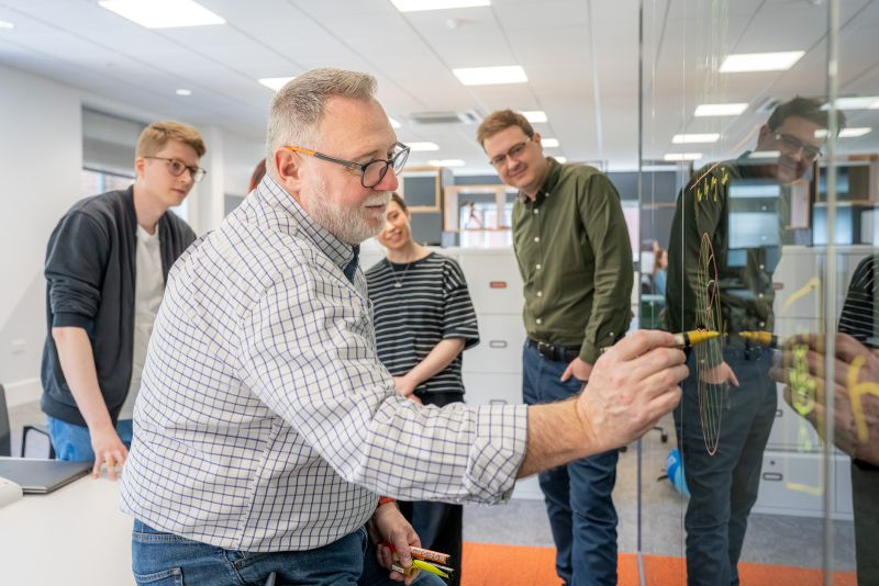 Colleagues collaborating at a glassboard